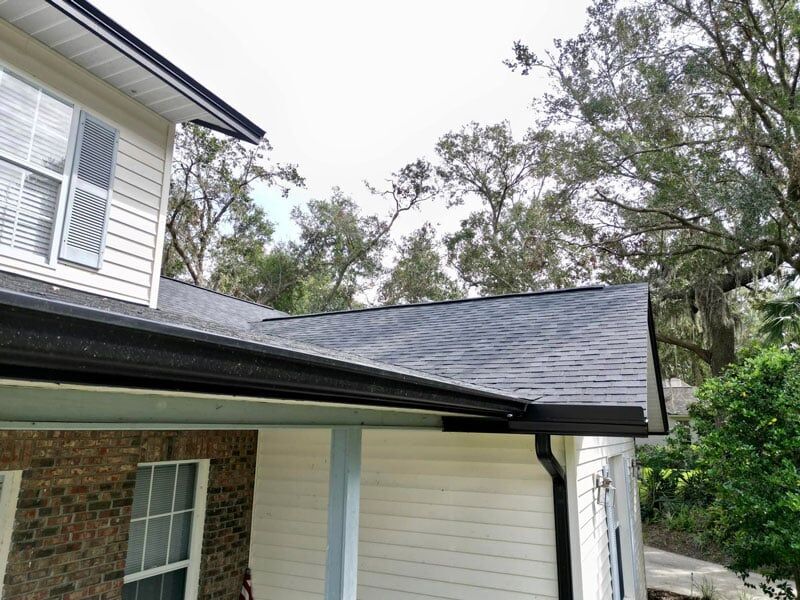 home with dark roof and gutters